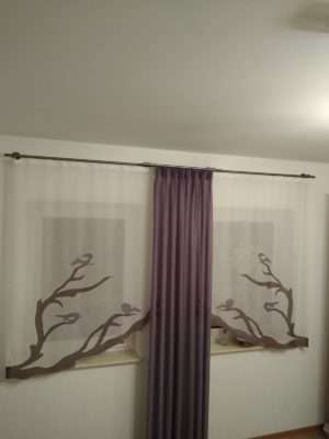 Fensterdekoration mit gemusterten Gardinen