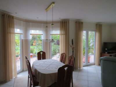 Gardinen in verschiedenen Farben und Längen am Fenster angebracht